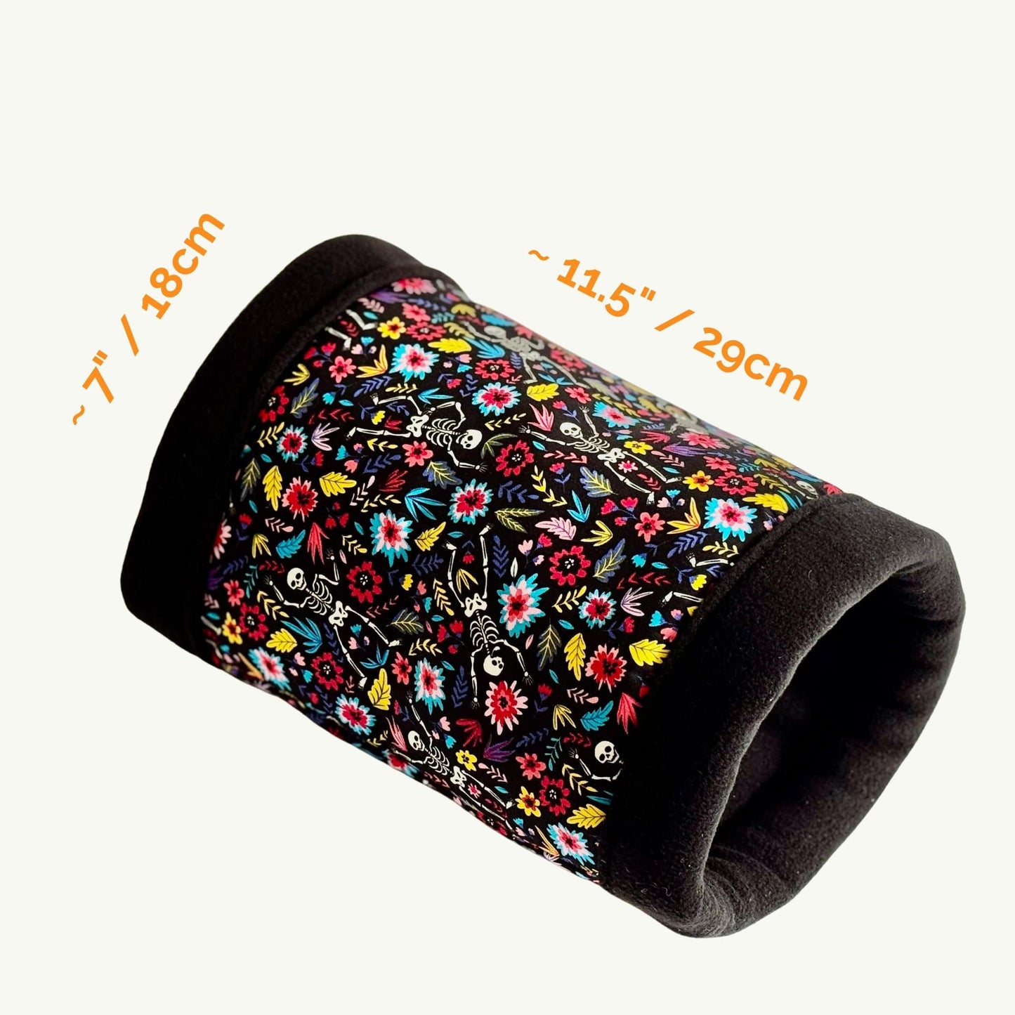 The Blooms & Bones Fleece Tunnel invites your little familiar to scurry through a plush gothic sanctuary—soft black ends frame a velvety tunnel adorned with lively blossoms entwined around whimsical skeletons. Measuring approximately 7 inches (18 cm) wide and stretching a cozy 11.5 inches (29 cm) long, this enchantingly eerie hideaway blends floral charm with spooky-cute flair, promising comfort and style for your guinea pig or small companion.
