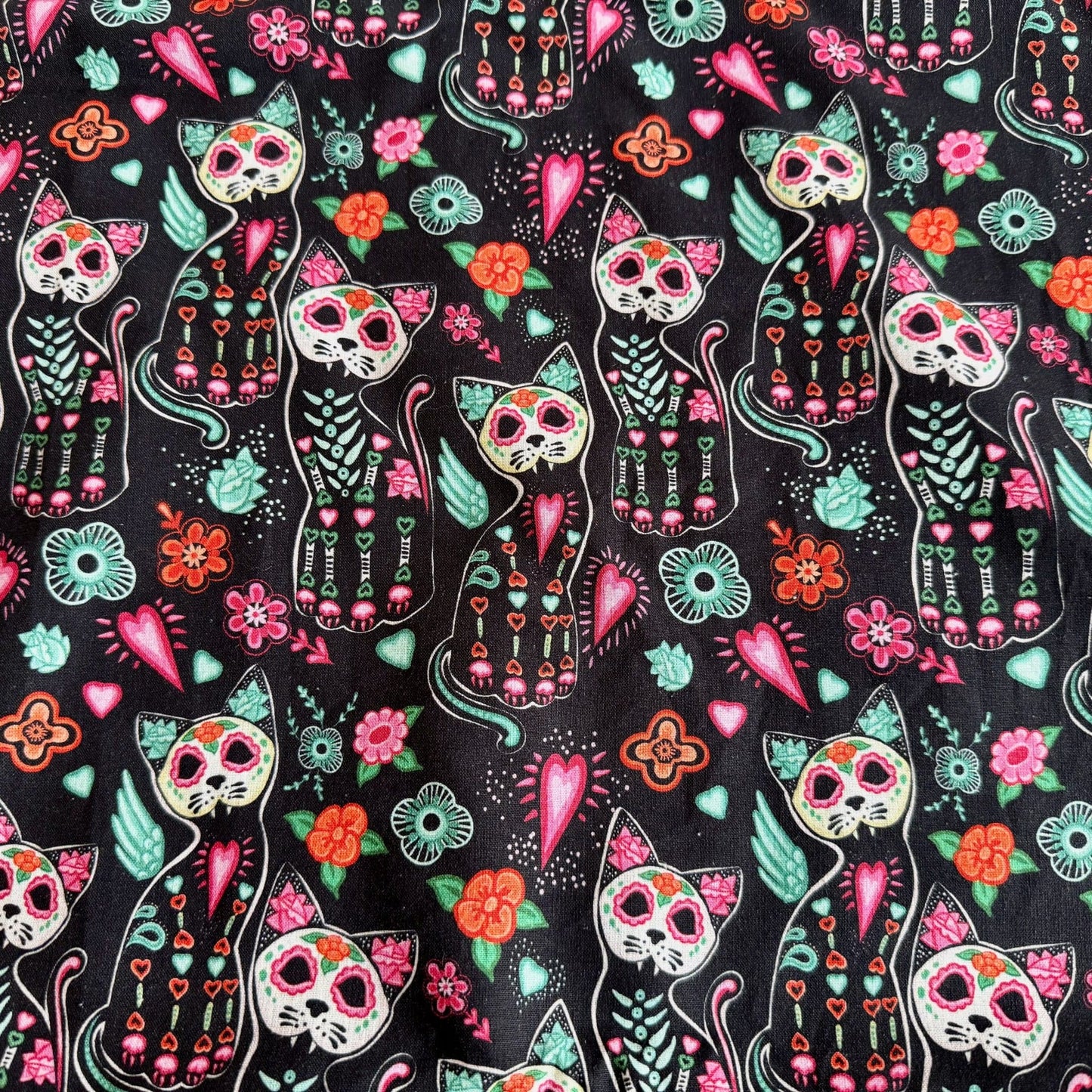 Spooky-cute alt text: Curious Catrina Large 2x1 Fleece Forest beckons your piggies into a gothic wonderland! Midnight-black fleece is adorned with enchanting sugar skull cats, their faces painted in hauntingly lovely colors. Skeleton whiskers mingle with bursts of vivid flowers, cheerful hearts, and swirling leaves—all shimmering in jewel tones. A whimsical hideaway where your small friends can scamper beneath spellbinding blossoms and cuddle up with charming feline spirits!.