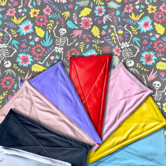 Blooms & Bones Matching Pee Pads: A bewitching bundle of plush fleece pads, folded like secret spells in enchanting shades—blood red, moonbeam yellow, witchy pinks and purples, midnight black, dreamy blue, and ghostly beige. These cozy squares rest atop a gothic garden of skeletons entwined with shadowy florals—a whimsically eerie stage for your guinea pig’s daily haunt. Cleanup has never been so magical (or stylish)!.