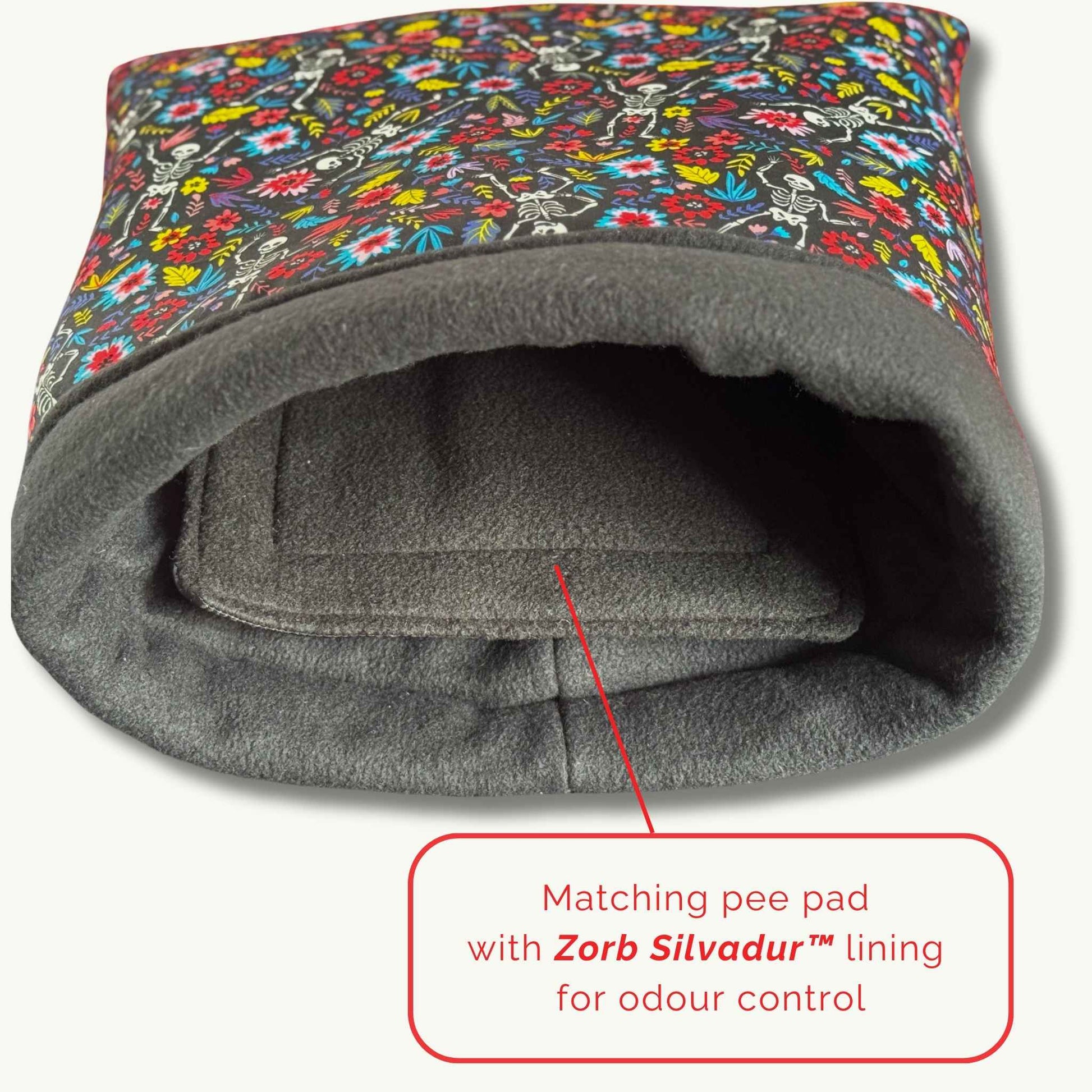 The Blooms & Bones Snuggle Sack, draped in gothic florals and skulls, cocoons your guinea pig in plush grey fleece and cozy magic.