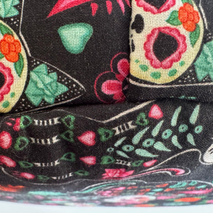 Bewitching close-up of the Curious Catrina Fleece Bed—luxuriously soft bedding adorned with enchanting sugar skulls and gothic florals in vivid reds, lush greens, and playful pinks, all set against an inky black background. A whimsy-packed Day of the Dead motif that’s both spooky and sweet—the perfect cozy crypt for guinea pigs or small pets dreaming beneath moonlit, magical blooms.