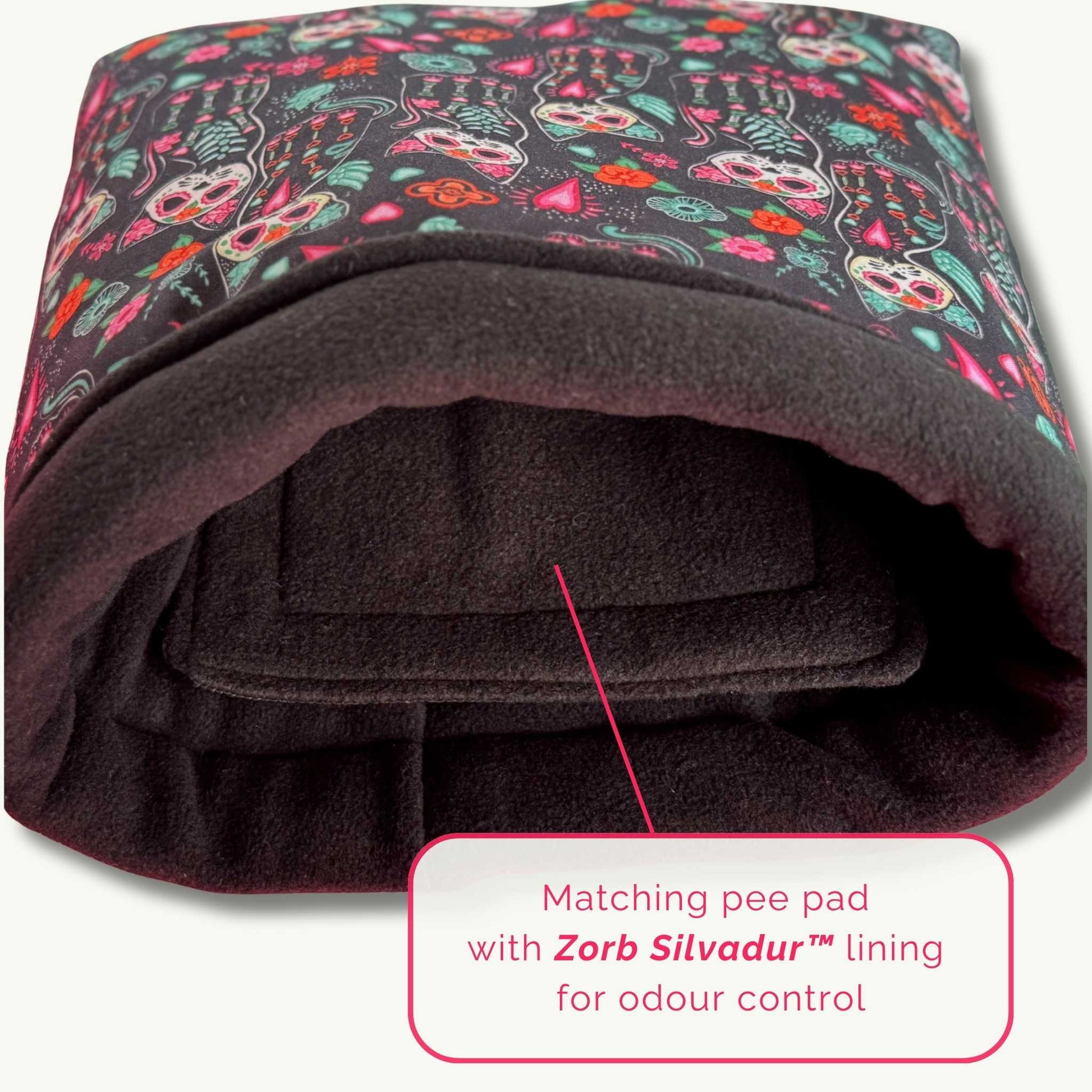 Enchant your guinea pig with this gothic-glam snuggle sack—festive skeletons, plush black fleece, and a Zorb Silvadur™ pee pad inside.