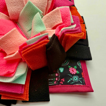 Enchant your pet’s world: pink, mint, orange & black fleece ruffles bloom on a floral mat—treats await in this gothic-glam garden!.