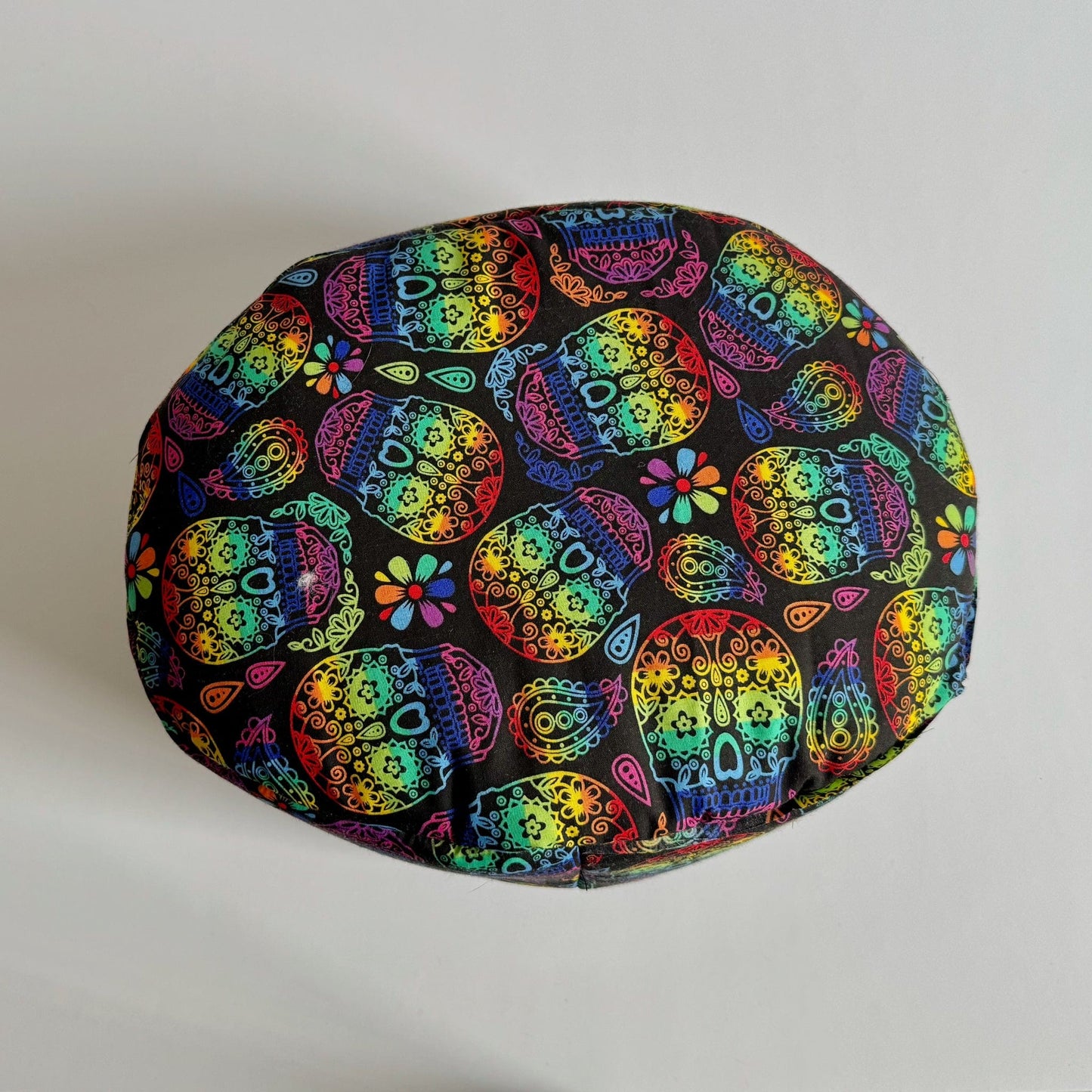 The Frightful Fiesta Fleece Bed is a whimsically spooky, round pet bed cloaked in midnight-black fleece, adorned with dazzling sugar skulls and gothic blossoms in bold pops of pink, teal, orange, and violet. This cozy resting spot is perfect for guinea pigs or other small familiars craving a dash of haunted glam—where every nap feels like a moonlit masquerade.