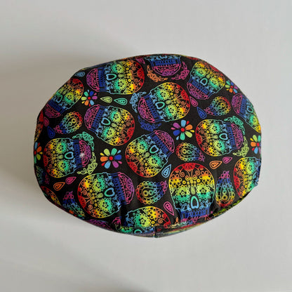 The Frightful Fiesta Fleece Bed is a whimsically spooky, round pet bed cloaked in midnight-black fleece, adorned with dazzling sugar skulls and gothic blossoms in bold pops of pink, teal, orange, and violet. This cozy resting spot is perfect for guinea pigs or other small familiars craving a dash of haunted glam—where every nap feels like a moonlit masquerade.