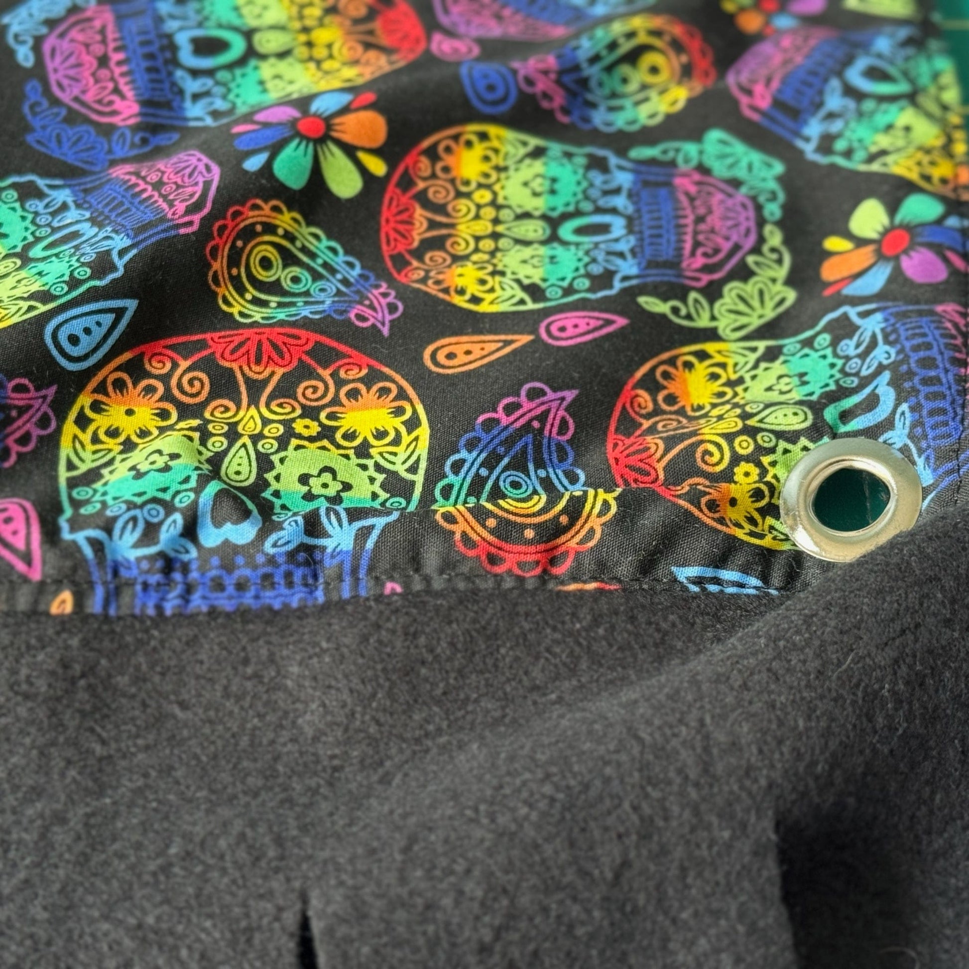 The Frightful Fiesta Large 2x1 Fleece Forest dazzles in gothic-glam style—a cascade of silken fleece strips adorned with enchanting rainbow sugar skulls and bewitching flowers swirling on midnight-black fabric. Perfect for guinea pigs who dream in moonlight, this cozy forest invites your little familiars to frolic in its magical shadows. A silver metal grommet gleams from the corner, adding just a hint of mysterious edge to their supernatural hideaway.