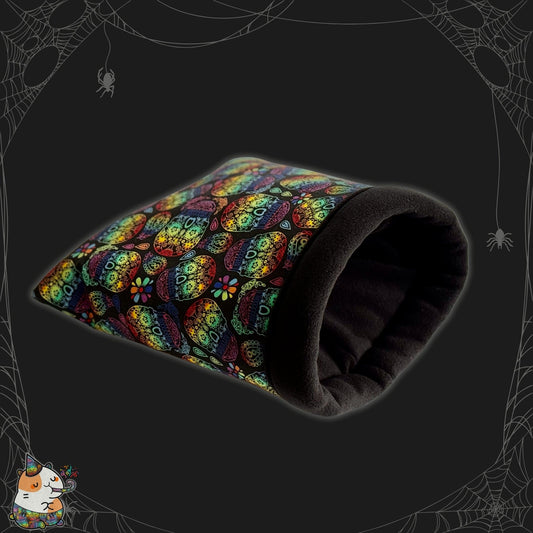 The Frightful Fiesta Snuggle Sack conjures a charmingly spooky hideaway for guinea pigs—a gothic-glam delight! This cozy pouch features vivid rainbow sugar skulls dancing across midnight-black fabric, entwined with silvery spiderwebs and playful little spiders. The plush fleece lining promises a snuggle fit for a vampire’s familiar. In one corner, Fiesta the Fabulous—the design mascot—keeps watch over your pet’s haunted dreams.