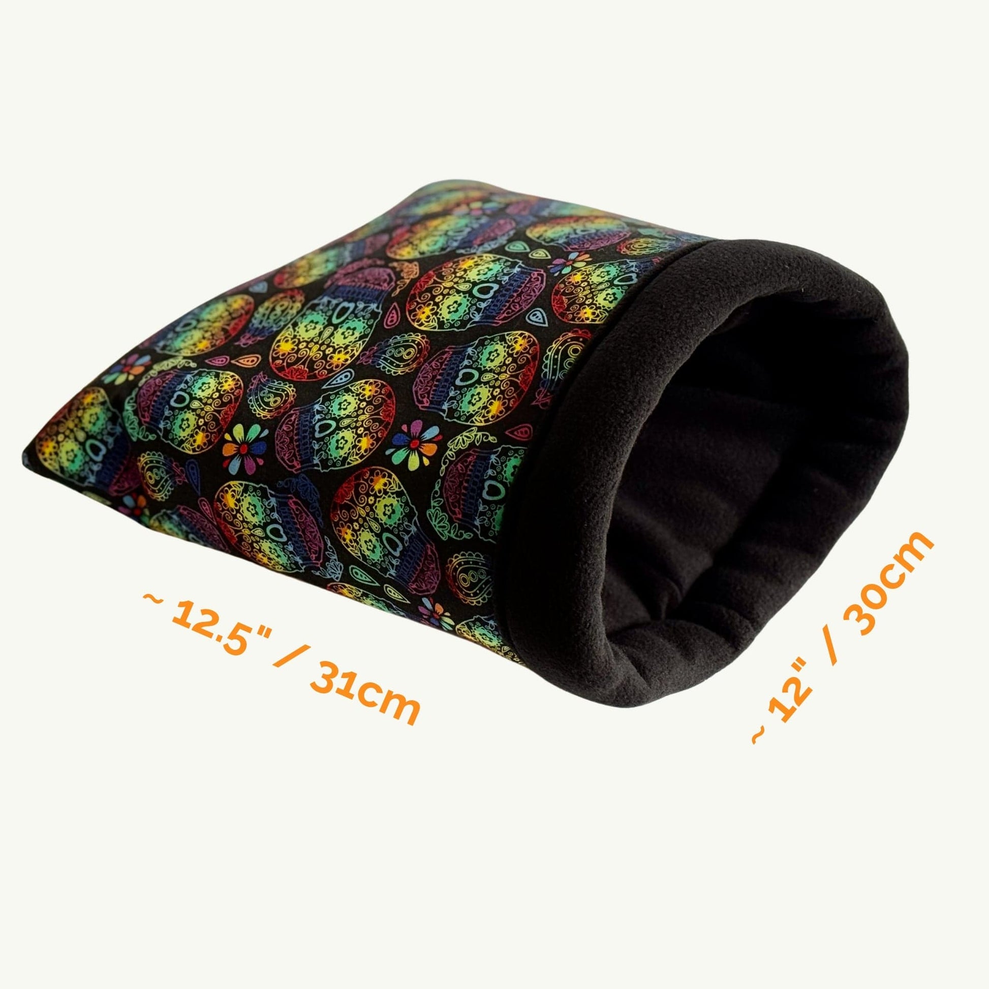 The Frightful Fiesta Snuggle Sack—a ghoulishly delightful tunnel—boasts a riot of vibrant, candy-colored patterns swirling across the outside, with a deep midnight-black lining for cozy gothic cuddles. Nestled atop a pale surface, this plush hideaway measures about 12.5 in (31 cm) long by 12 in (30 cm) wide, enchanting guinea pigs and small pets who crave a dash of spooky-cute glamour in their nightly haunt.