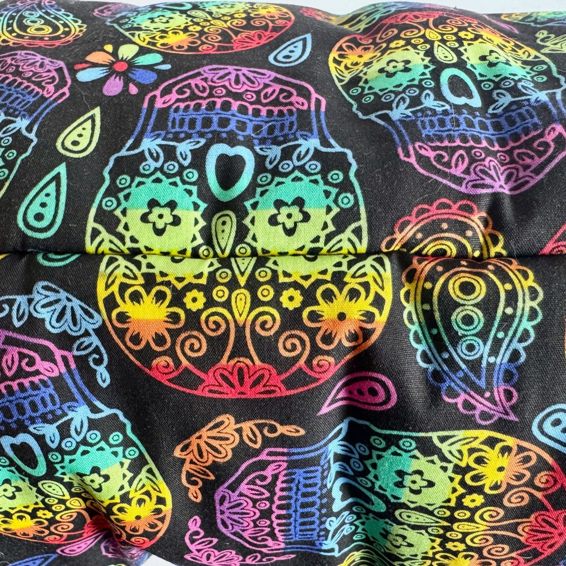 The Frightful Fiesta Snuggle Sack glimmers with neon sugar skulls and swirling paisley on inky midnight-black fabric, adorned with vivid gothic florals. Inside, a plush fleece lining invites guinea pigs to burrow into spellbinding comfort—perfect for haunting dreams or snuggling under the full moon.