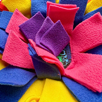 Glimpse neon pink, purple, blue, and yellow fleece strips swirling on the Frightful Fiesta Snuffle Mat—centered by a gothic tag.