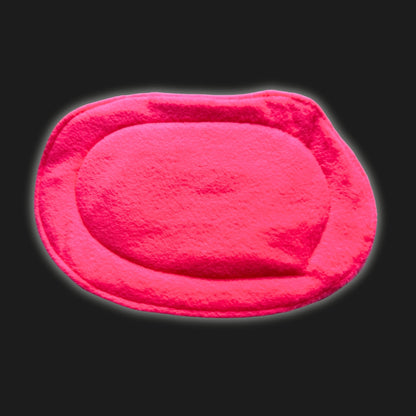 A hauntingly adorable, neon pink fleece liner and pee pad, shaped in a whimsical oval with softly uneven, plush edges. The pad’s velvety fuzz casts a dreamy glow against the midnight-black backdrop, conjuring visions of gothic glamour for your small pet’s lair. The washable fleece shimmers like enchanted moonlight—spooky-cute comfort for guinea pigs or little familiars alike.