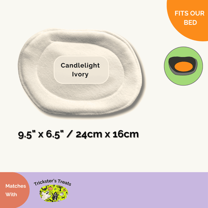 An enchanting oval pet bed insert in ghostly Candlelight Ivory, sized just right for cozy piggies—pairs wickedly well with Trickster’s Treats Pee Pads!.