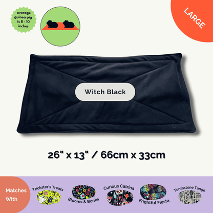 A spellbinding black mat—Trickster’s Treats (26 x 13 in)—paired with vibrant fleece pads and guinea pigs conjure a gothic Halloween charm.