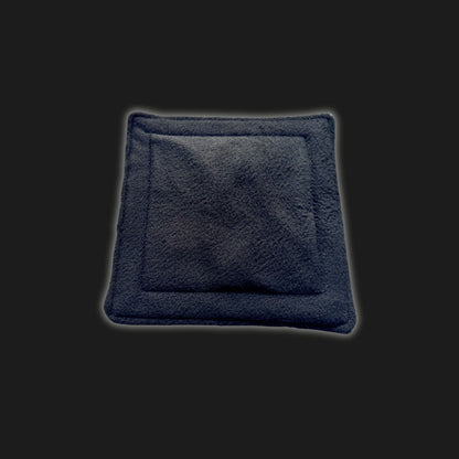 Enchant your little familiar’s lair with our Modular Fleece Liner & Pee Pad—a plush, midnight-black square of cozy fleece, edged in delicate gothic stitching and adorned with a subtle, coffin-inspired indented center. Perfect for pampered paws and mysterious midnight scurries. Shown resting atop an inky black backdrop, this bewitching pad promises both comfort and dramatic flair for your petite companion.