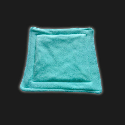 Nestled against a shadowy black backdrop, a hauntingly adorable, mint green fleece liner and pee pad set awaits your tiny familiar. This bewitching square features enchanting stitched edging and a plush, slightly raised center—perfect for cozy midnight burrows. Each modular piece is lovingly conjured for guinea pigs and small creatures seeking gothic-glam comfort in their enchanted lair.