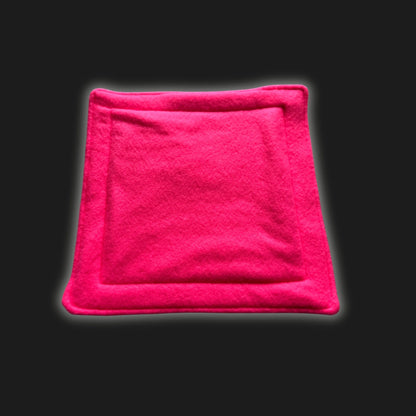 Bewitching neon pink fleece liner and matching pee pad, both cut in perfect squares and edged with enchanting stitched borders. Set against a pitch-black backdrop, this cozy gothic-glam set glows with spectral charm—perfect for pampered guinea pigs or small familiars who love a little midnight mischief!.