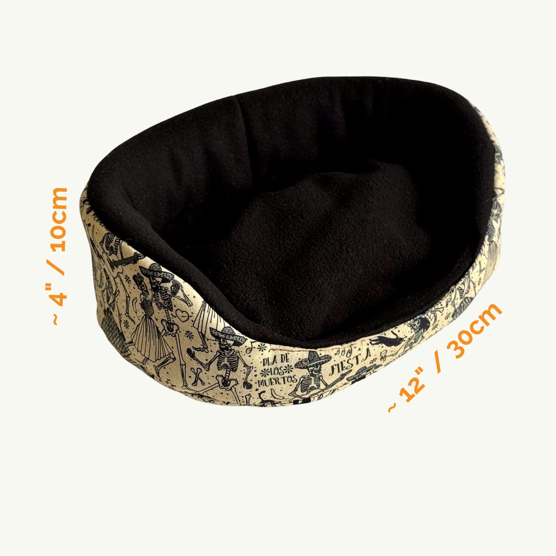 The Tombstone Tango Fleece Bed is cozy crypt chic, featuring a plush black interior and a vintage beige exterior that looks like moonlit stone. An orange label adds a pop of pumpkin charm. Measuring 4 inches tall by 12 inches wide, it’s the purrfect haunted hideaway for guinea pigs and little beasties to snuggle in style.