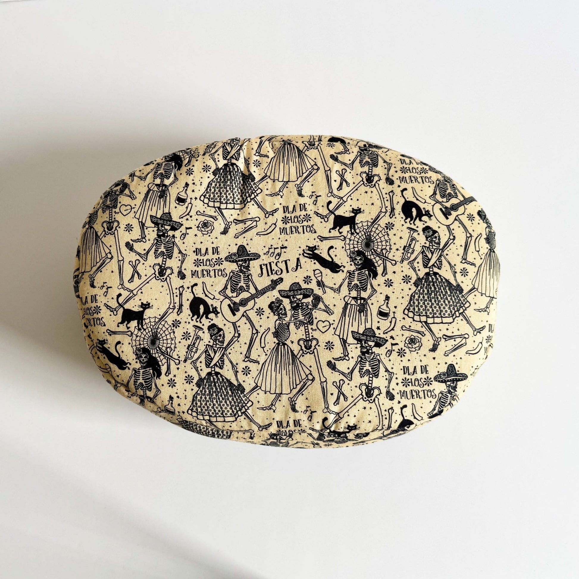 The Tombstone Tango Fleece Bed is a plush, round cushion—its creamy beige fabric bewitched with inky-black sketches of skeleton dancers and fanciful musicians swirling across the surface. Playful gothic script proclaims “Viva la Vida” among festive skulls, roses, and swirling bats. A haunt-fully cozy nest for guinea pigs or other small companions to curl up in style, blending supernatural charm with snug comfort.