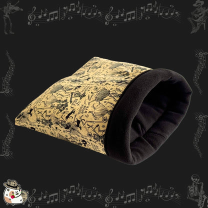 The Tombstone Tango Snuggle Sack is a bewitchingly cozy tunnel for guinea pigs and small pets, stitched from antique-inspired beige cotton patterned with whimsical black skeletons mid-dance and floating music notes. Finished with a plush black fleece lining for gothic glam comfort, this snuggle sack invites your little familiar to curl up in soft, spooky elegance—perfect for paranormal naps or midnight cuddles.