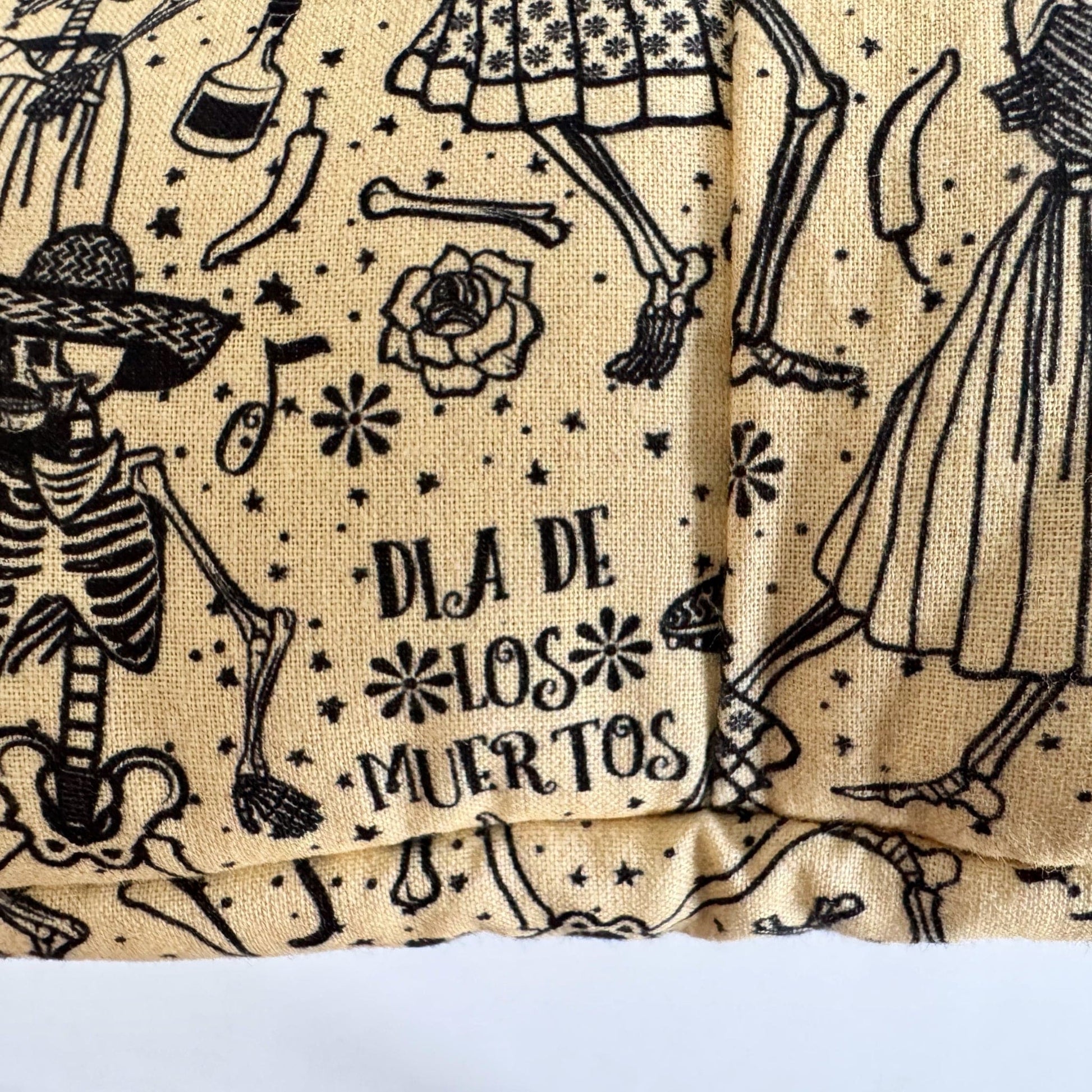 The Tombstone Tango Snuggle Sack is a beige fleece pouch for guinea pigs, conjuring gothic-glam whimsy with its parade of black skeletons adorned in dapper dresses and jaunty hats. Festive florals, frolicking bones, and ornate patterns waltz across the sack, while DIA DE LOS MUERTOS glimmers at the center—inviting your tiny familiar to slumber in spectral style.