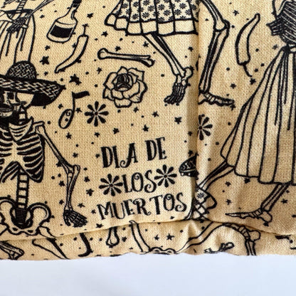 The Tombstone Tango Snuggle Sack is a beige fleece pouch for guinea pigs, conjuring gothic-glam whimsy with its parade of black skeletons adorned in dapper dresses and jaunty hats. Festive florals, frolicking bones, and ornate patterns waltz across the sack, while DIA DE LOS MUERTOS glimmers at the center—inviting your tiny familiar to slumber in spectral style.