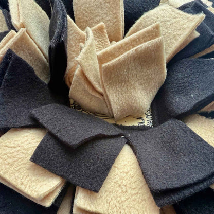 Enchanting close-up of the Tombstone Tango Snuffle Mat with ruffled black and beige fleece strips—where treats haunt velvet shadows.