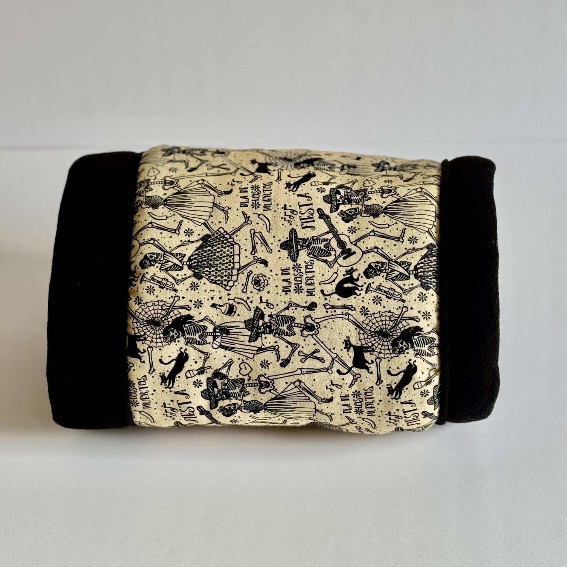 The Tombstone Tango Fleece Tunnel—a whimsically gothic hideaway—features luxe black edges framing a soft cream center. Adorned with playful skeleton critters draped in dapper, festive attire, each strikes a charming pose among midnight roses and moonlit garden vines. Ornate gothic script dances across the tunnel, inviting your small pet to revel in cozy, spooky-glam style.