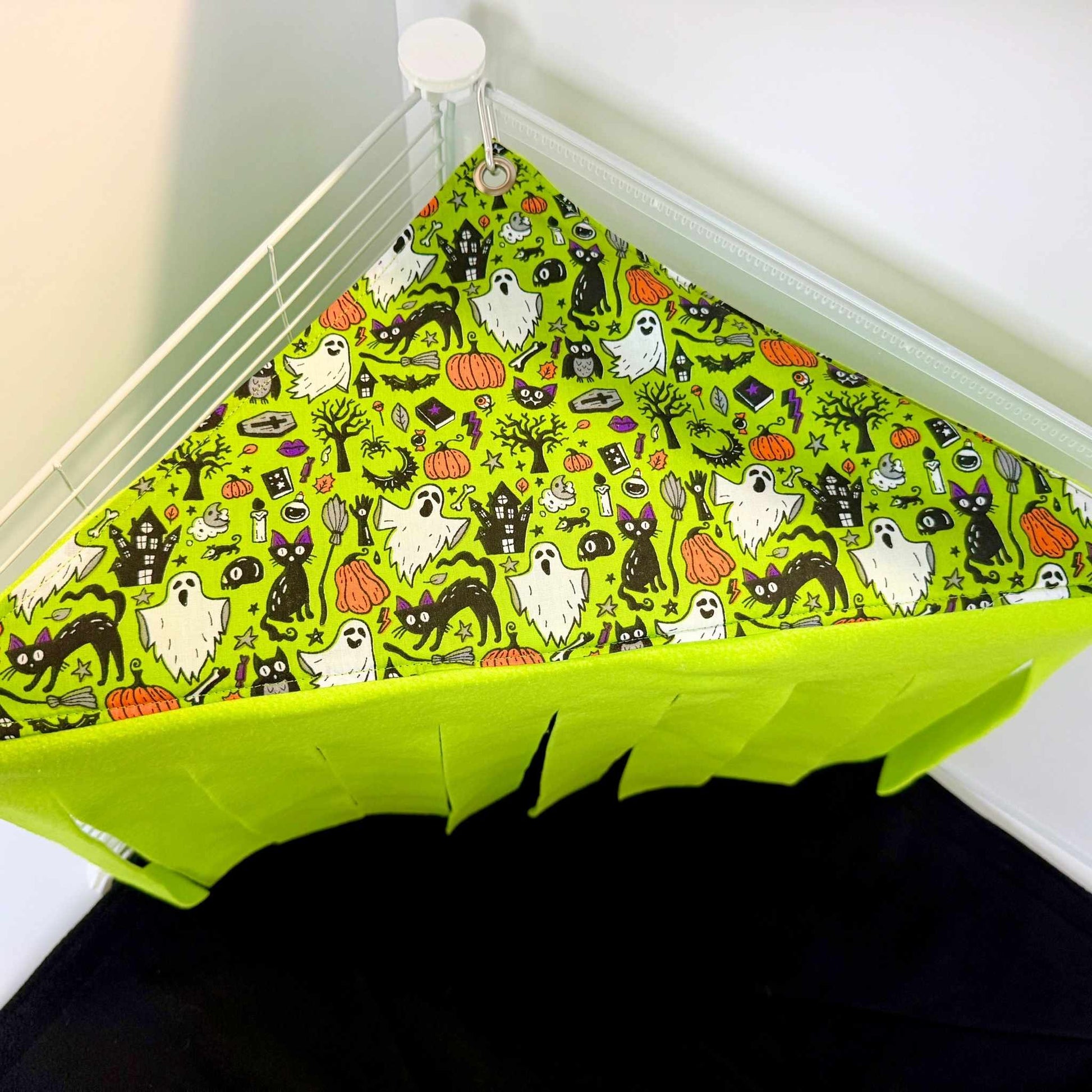 The Trickster’s Treats Corner Fleece Forest flaunts goth-glam ghosts, bats, cats, and pumpkins; eerie green strips sway below.