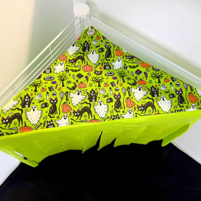 The Trickster’s Treats Corner Fleece Forest flaunts goth-glam ghosts, bats, cats, and pumpkins; eerie green strips sway below.